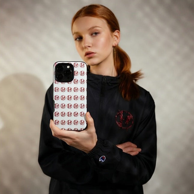 Person holding a phone case with a pattern, wearing a black outfit.